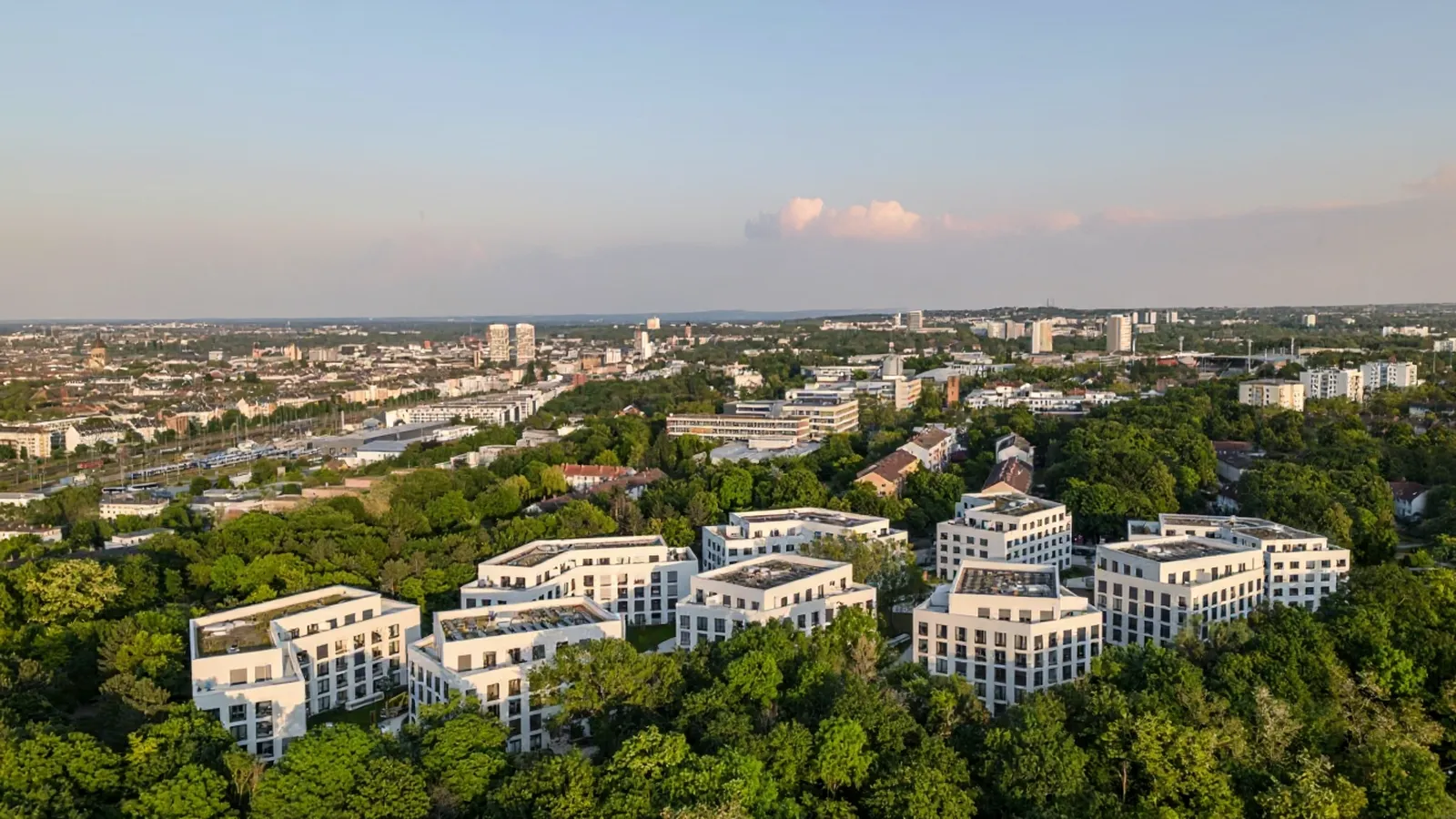 Luftbild von Hartenberg-Münchfeld mit modernen Wohnanlagen im Grünen und Blick auf die Stadt