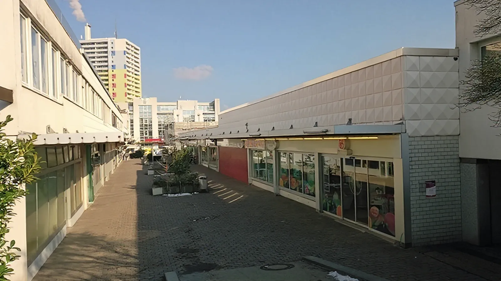 Einkaufspassage mit Geschäften und Hochhaus im Hintergrund in Mainz-Lerchenberg