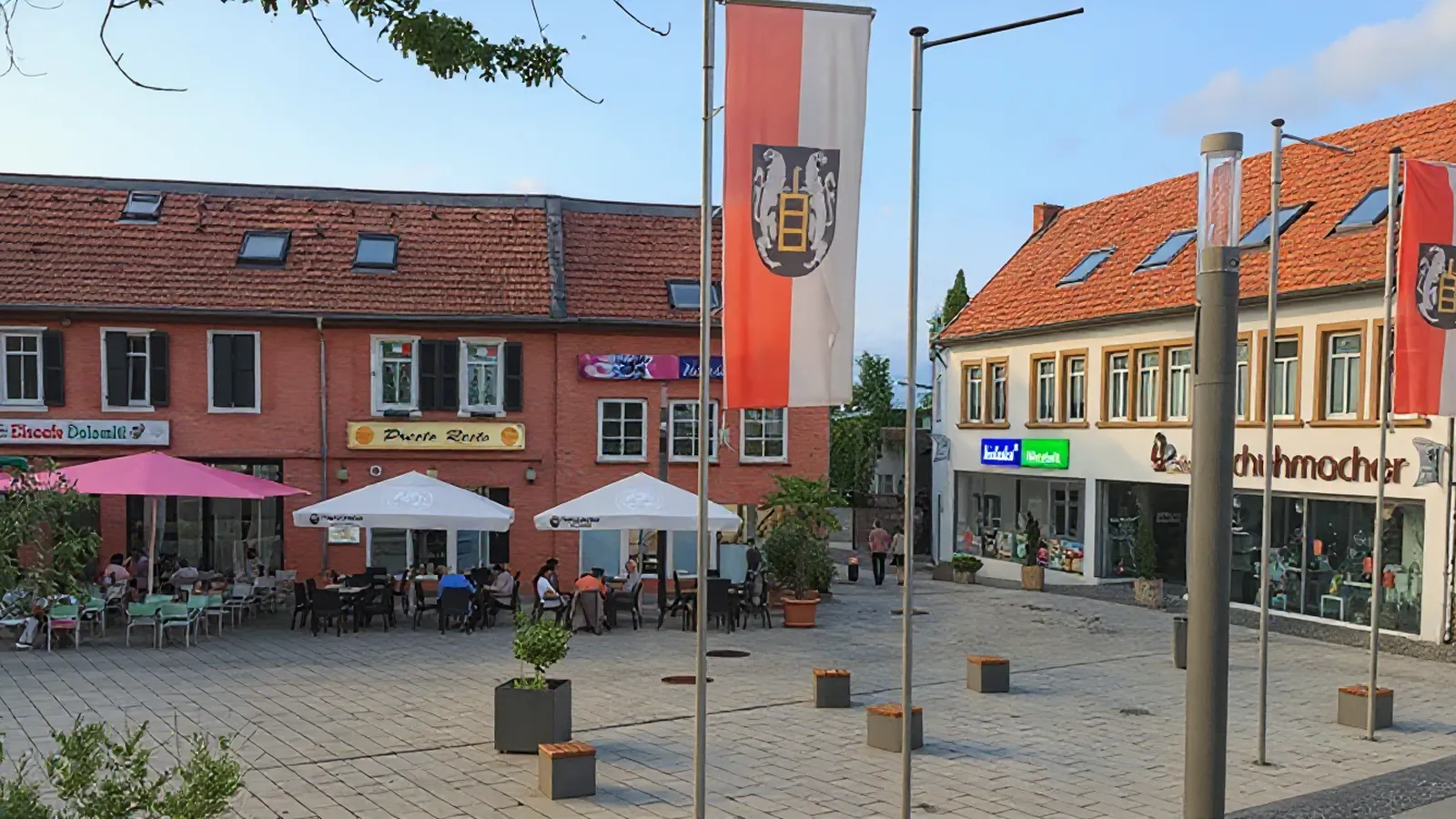Platz mit Cafés, Geschäften und Fahnen mit Ortswappen in Wörrstadt
